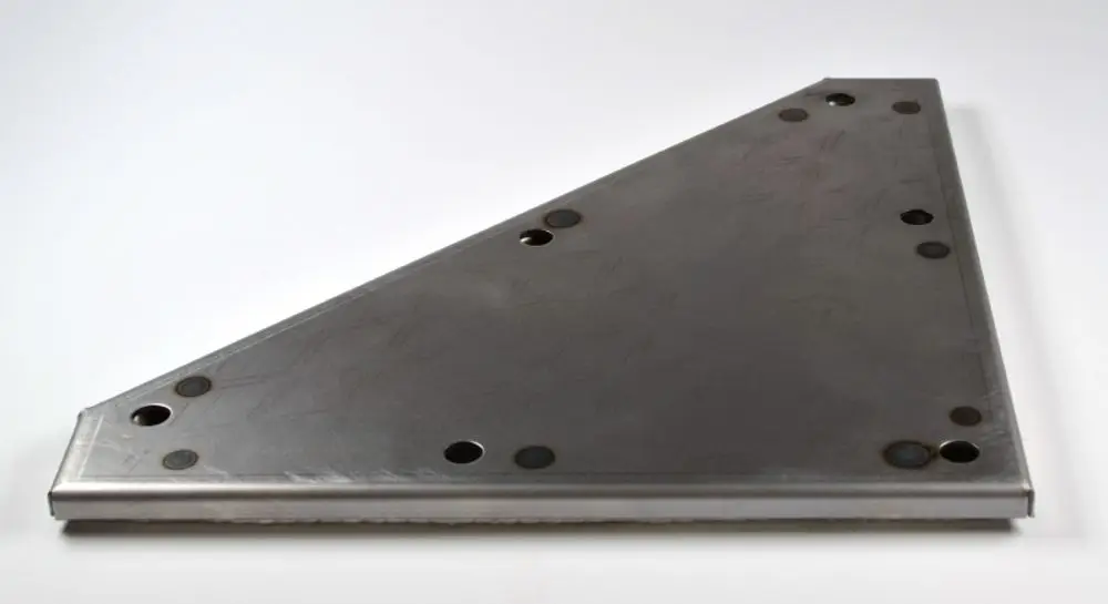 Metallisches Rechteck mit schräger Kante und mehreren Löchern, voraussichtlich für eine Abdeckung. Produkt von Remko, geeignet für Revisionen oder Wartungsarbeiten.