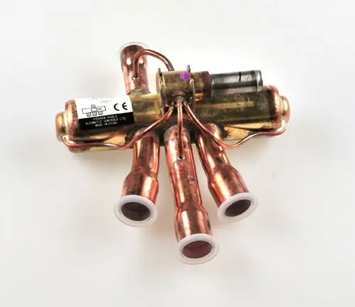 Umkehrventil mit mehreren Kupferrohren und elektrischer Komponente, hergestellt von Remko. Das Produkt hat ein kompaktes Design und wird in spezifischen Klimaanlagen verwendet.