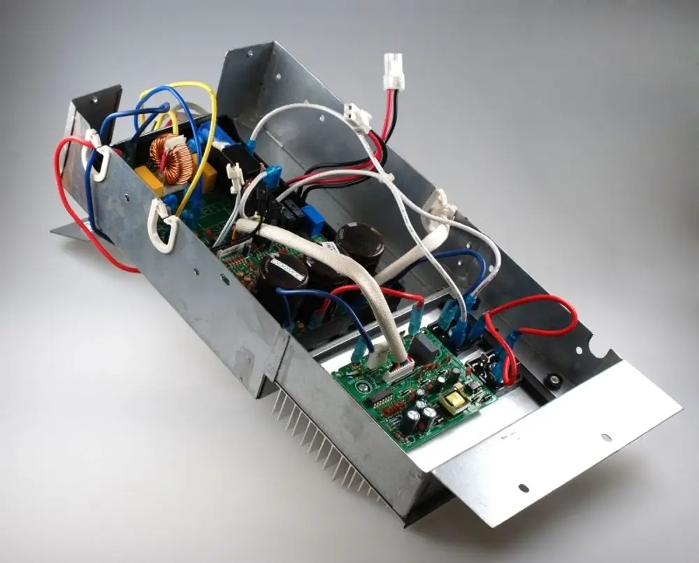 Offene Gehäuseeinheit mit Leiterplatten und Kabeln, vermutlich Teil eines elektrischen Geräts, hergestellt von Remko. Sichtbare Komponenten umfassen Kondensatoren und Transformatoren.