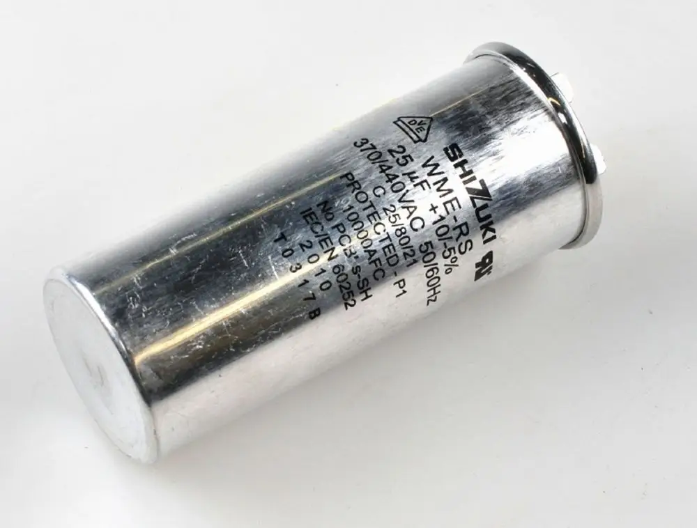 Kondensator von Remko mit silberner Metalloberfläche und beschriftetem Gehäuse, verwendet in Kompressoranwendungen. Anschlüsse sind an der Oberseite sichtbar.