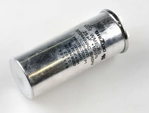 Kondensator von Remko mit silberner Metalloberfläche und beschriftetem Gehäuse, verwendet in Kompressoranwendungen. Anschlüsse sind an der Oberseite sichtbar.