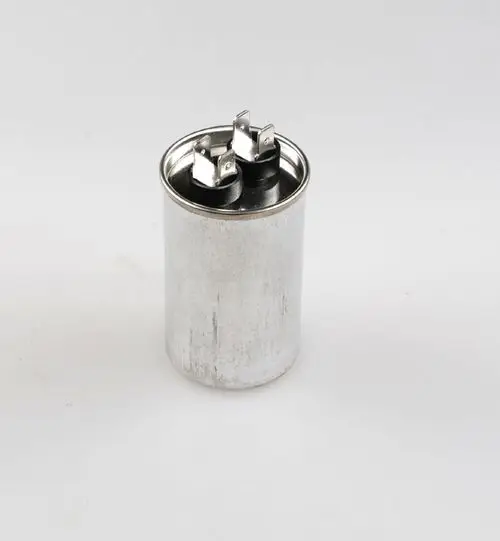Kondensator von Remko, zylindrische Metallkonstruktion mit zwei Anschlüssen oben, auf neutralem Hintergrund.