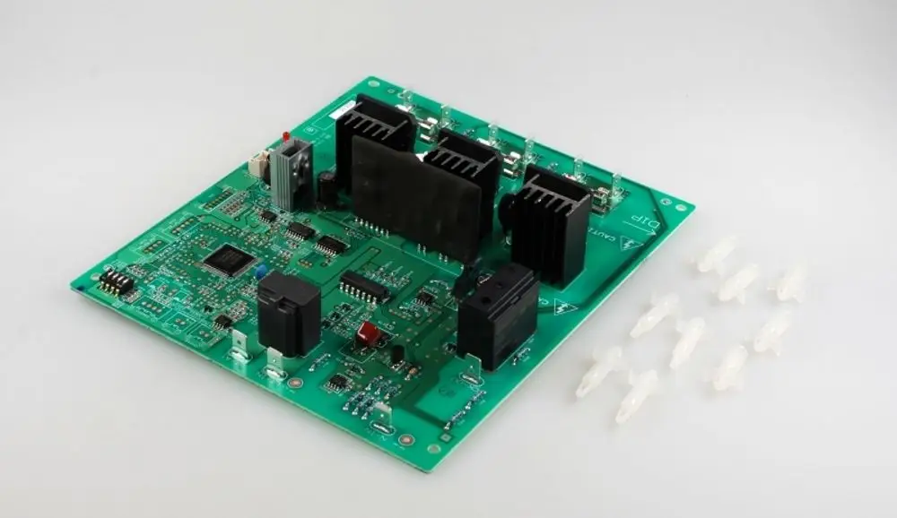 Grüne Leiterplatte mit mehreren Komponenten, darunter Kühlkörper und elektronische Bauteile, daneben transparente Befestigungen. Produkt von Remko.