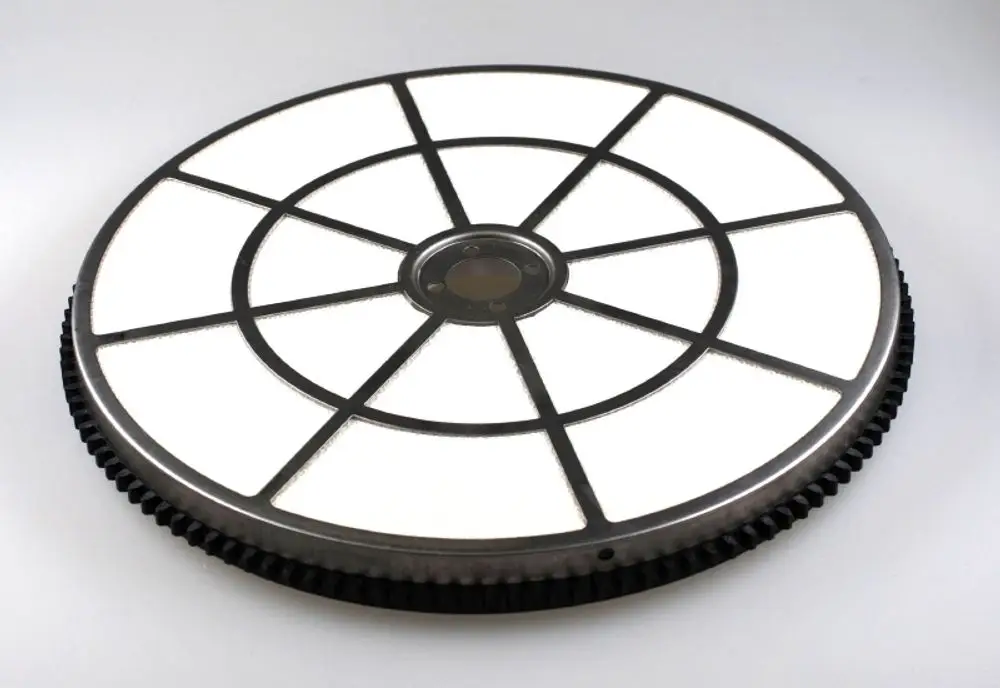 Runder Adsorptions-Rotor mit mehreren Sektionen und einem zentralen Antriebsbereich, hergestellt von Remko. Der Rotor hat eine schwarze Außenseite mit weißen Innenflächen.
