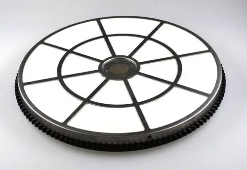 Runder Adsorptions-Rotor mit mehreren Sektionen und einem zentralen Antriebsbereich, hergestellt von Remko. Der Rotor hat eine schwarze Außenseite mit weißen Innenflächen.