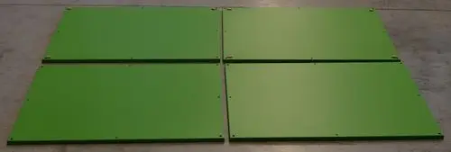 Grüne Metallplatten, flach und rechteckig angeordnet, möglicherweise Teil einer Baugruppe. Erkennbar sind Montagelöcher. Produkt von Remko.
