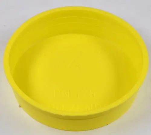 Gelber Kunststoffdeckel mit glatter Innenseite und geriffeltem Rand, geeignet für Behälterverschlüsse, produziert von Remko.