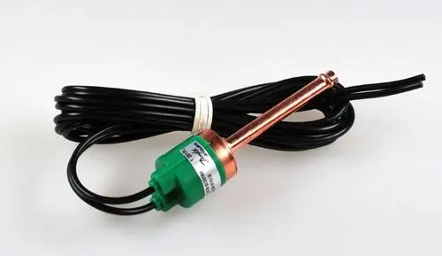 Hochdruckwächter mit grünem Gehäuse und kupfernem Anschlussrohr, umgeben von einem schwarzen Kabel. Produkt von Remko zur Drucküberwachung in Systemen.