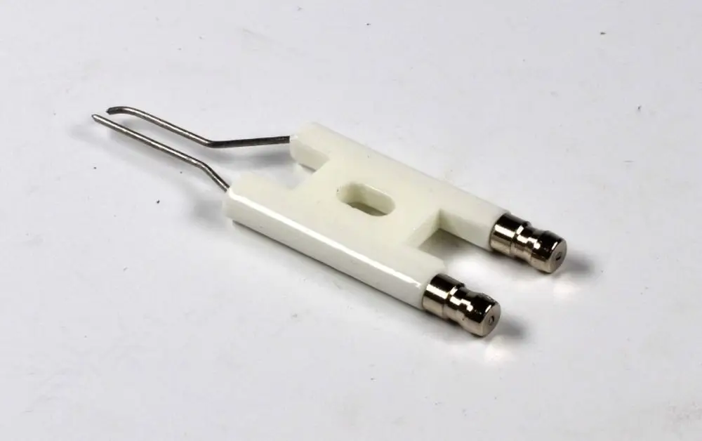 Weiße Zündelektrode mit zwei metallischen Anschlüssen und einem Doppeldraht, hergestellt von Remko. Das Produkt hat eine zentrale Durchlassöffnung.