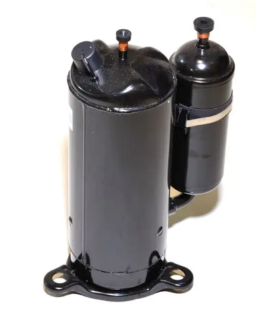 Schwarzer Kompressor von Remko mit zwei Anschlussöffnungen und einer Befestigungsbasis. Das Design ist zylindrisch, mit einer zusätzlichen kleineren Einheit an der Seite.