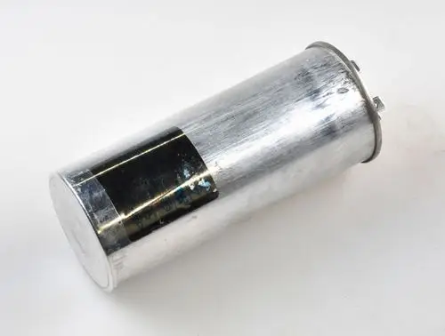 Aluminiumboden-Kondensator mit zwei Verbindungspins. An der Seite ein schwarzes Etikett. Hersteller: Remko.