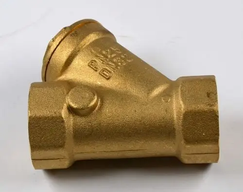 Remko Schmutzfänger in Gold, metallisch, mit zwei Anschlussgewinden und einer anschraubbaren Oberseite, im schrägen Design, zur Filterung von Verunreinigungen in Rohrsystemen.