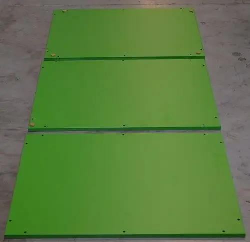 Drei grüne Metallplatten liegen nebeneinander auf einem grauen Untergrund. Sie sind mit Bohrlöchern versehen und könnten Teil eines Remko-Produkts sein.