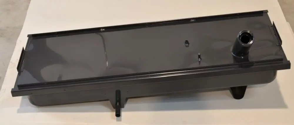 Brennstoffbehälter in dunkler Farbe mit seitlicher Öffnung, gefertigt von Remko. Die flache, rechteckige Form ist auf einem hellen Untergrund sichtbar.