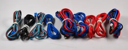 Kabelset von Remko mit mehreren farbigen Kabeln in Schwarz, Blau und Rot, jeweils mit Schlaufen, auf einem neutralen Hintergrund angeordnet.