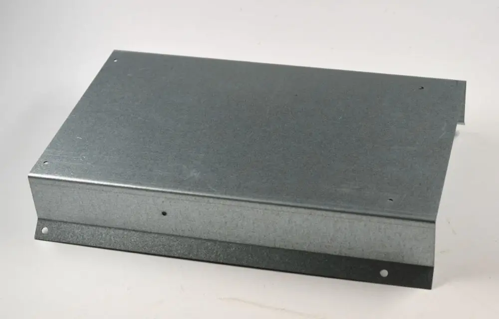 Metallisches, rechteckiges Gehäuse mit schmalem Rand und Befestigungslöchern, passend zu Remko Geräten. Oberfläche ist silberfarben und aus verzinktem Material.