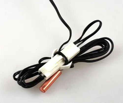 Sensor mit schwarzem Kabel, weißer Halterung und kupferner Spitze, hergestellt von Remko. Ideal für Anwendungen in Lamellentauschern.