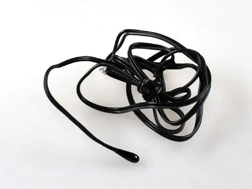 Schwarzes, verknäultes Kabel ohne erkennbare Markenkennung. Möglicherweise Teil eines Sensors von Remko. Ungeordnete Anordnung auf heller Fläche.