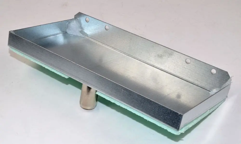 Kondensatwanne aus Metall mit einer grünen Unterlage und einer zentralen Halterung. Sie gehört zur Ventilbaugruppe von Remko und ist für vertikale Anwendungen konzipiert.