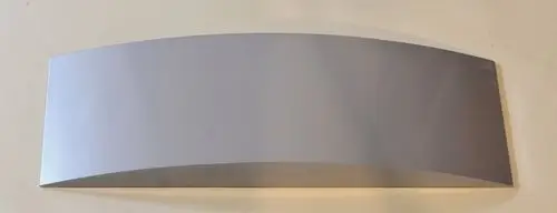 Silbernes, gebogenes Metallblech auf hellem Hintergrund, vermutlich ein Teil von einem Gerät oder einer Installation, möglicherweise von der Marke Remko.