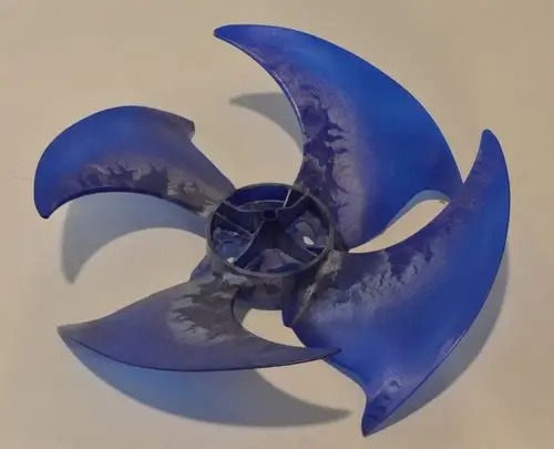 Blauer Ventilatorflügel von Remko, mit vier geschwungenen Blättern und einer zentralen Halterung. Der Flügel zeigt Abnutzungserscheinungen.
