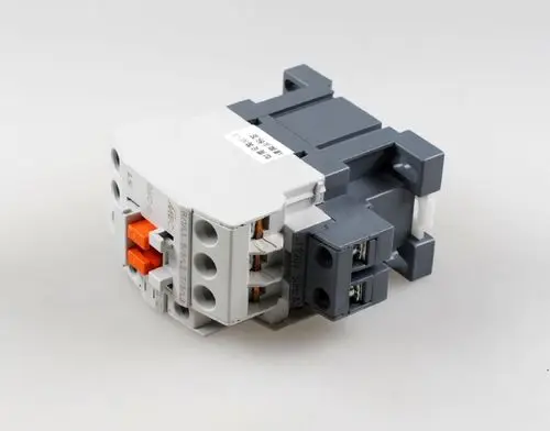 Schütz von Remko in grauer und weißer Ausführung mit mehreren Anschlussklemmen und orangefarbenen Betätigungselementen, für die Steuerung elektrischer Geräte geeignet.