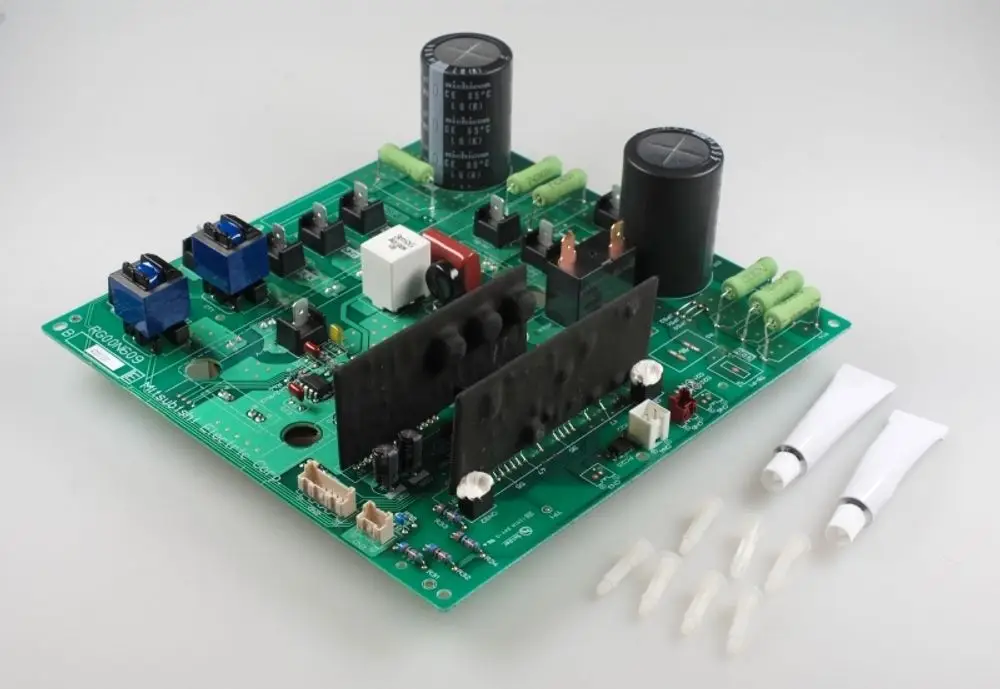 Platine mit verschiedenen elektronischen Komponenten, darunter Kondensatoren und Anschlüsse, zur Verwendung in einem Remko-Gerät. Sichtbar sind Kleberöhren und Einsätze.