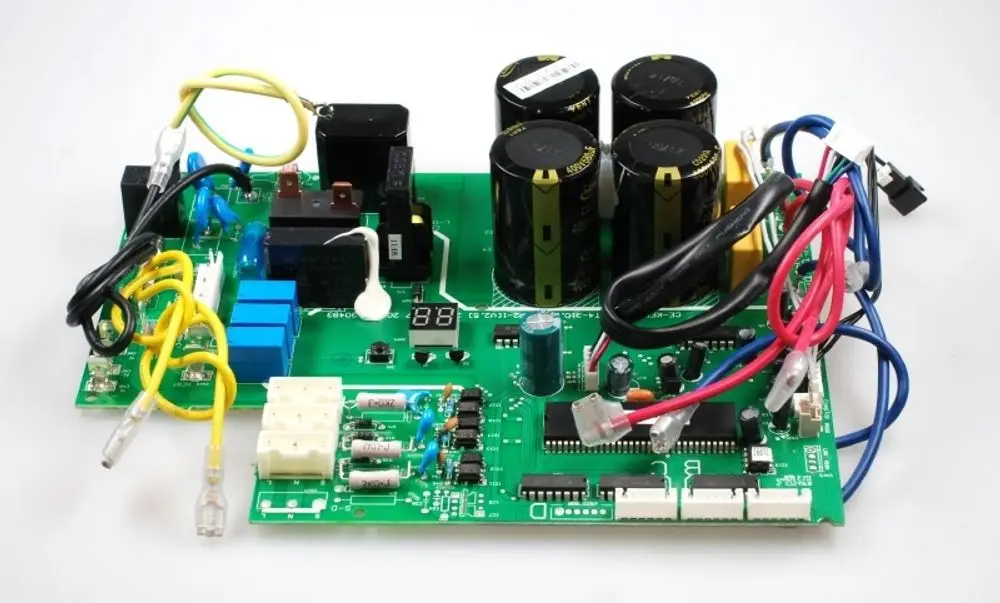 Steuerplatine von Remko mit mehreren elektrischen Komponenten, inklusive Kondensatoren, Relais und Anschlüssen, dargestellt auf grüner Leiterplatte mit Digitalanzeige.