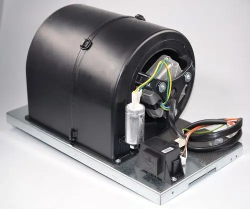 Ventilatoreinheit von Remko, mit einem runden Gehäuse, elektrischen Anschlüssen und einem montierten Kondensator. Metallbasis zur Stabilität erkennbar.