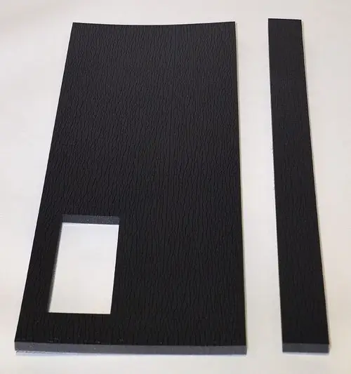 Dämmmaterial von Remko in schwarz, bestehend aus einer großen Platte mit rechteckiger Aussparung und einem schmalen Streifen. Textur mit feinen Rillen.