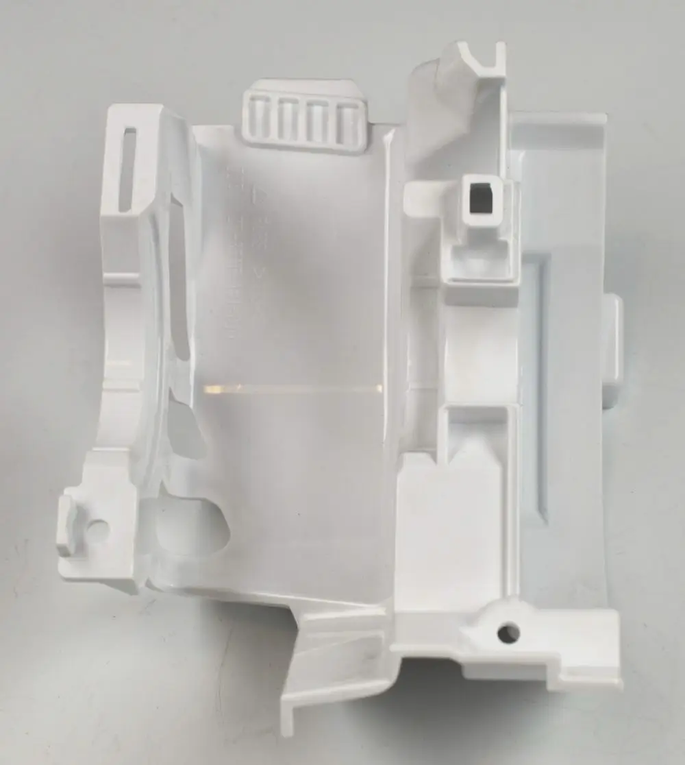 Weißer Kunststoffteil, vermutlich eine Abdeckung für einen Ventilatormotor. Hersteller ist Remko. Sichtbare Aussparungen und Halterungen.