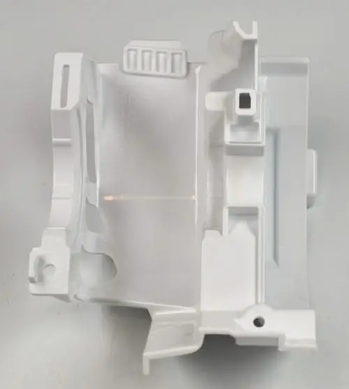 Weißer Kunststoffteil, vermutlich eine Abdeckung für einen Ventilatormotor. Hersteller ist Remko. Sichtbare Aussparungen und Halterungen.
