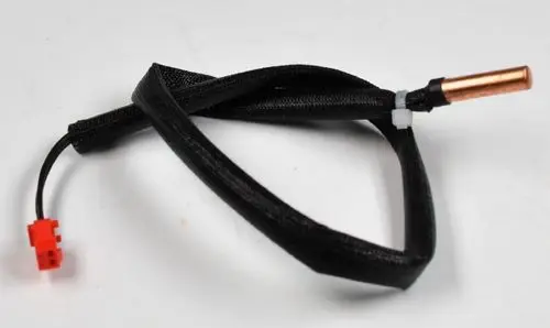 Rohranlegesensor mit schwarzem Kabel und rotem Stecker, verwendet in Kompressoren, hergestellt von Remko. Kupferende sichtbar.
