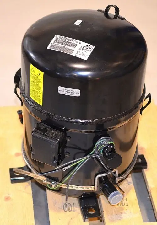 Schwarzer Remko-Kompressor mit elektrischen Anschlüssen und Ventileinheiten, auf Holzpalette präsentiert. Herstellerinformationen und Warnhinweise sichtbar.