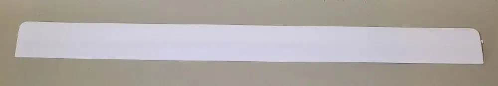 Weiße, schmale Lamelle von Remko, flach und länglich, auf neutralem Hintergrund, ohne erkennbare Maße oder weitere Details.