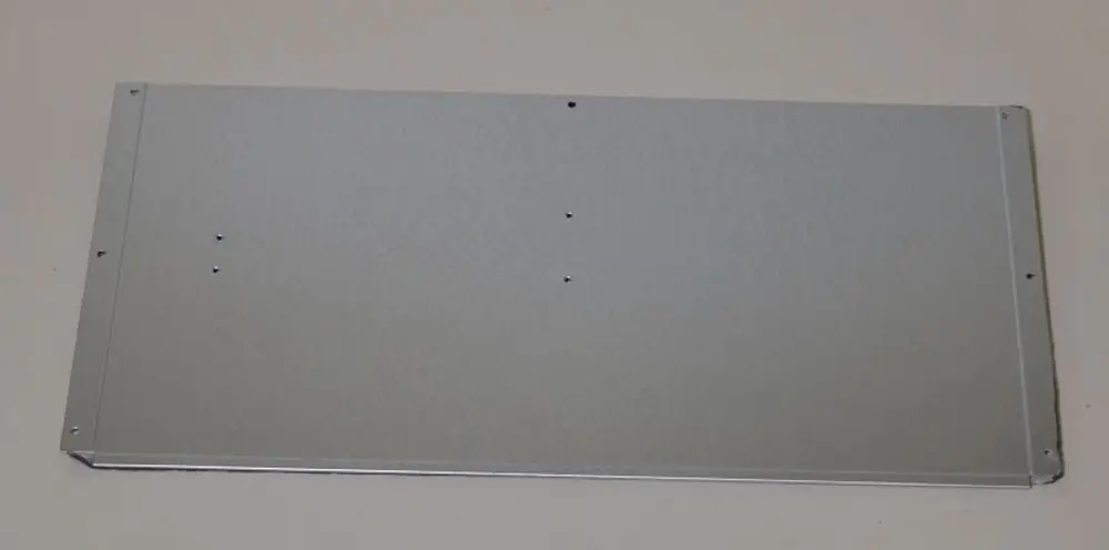 Verkleidungsteil aus Metall mit glatter Oberfläche, möglicherweise von Remko, zur Montage in einem technischen Kontext. Mehrere Bohrlöcher zur Befestigung sind sichtbar.
