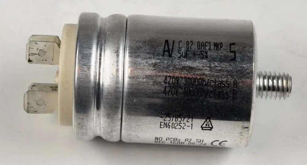 Kondensator von Remko, zylindrischer Metallkörper mit zwei Anschlussstiften und Gewinde, beschriftet mit technischen Spezifikationen.
