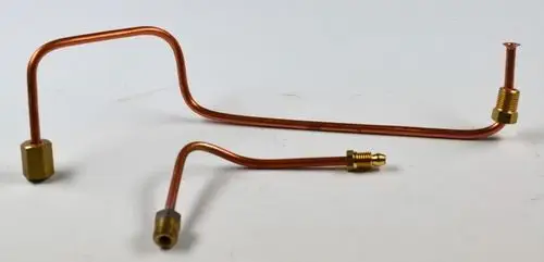 Zwei kupferne Zündgasrohre mit goldenen Anschlussstücken, die für Heizsysteme von Remko geeignet sind. Die Rohre haben unterschiedliche Biegungen und Längen.