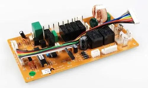Steuerplatine von Remko mit verschiedenen elektronischen Bauteilen, darunter Relais, Widerstände, und Anschlussleitungen auf einer orangenen Leiterplatte.