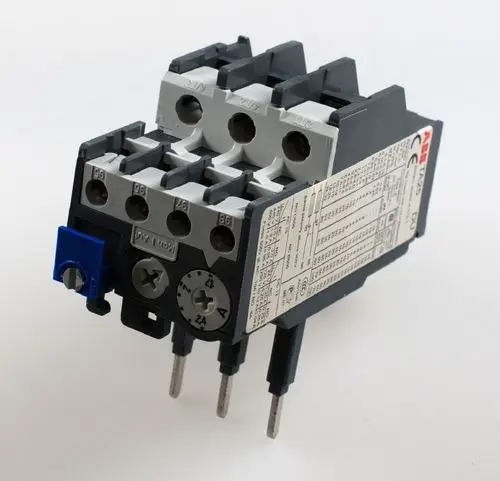 Remko Überstromrelais mit mehreren Anschlussklemmen und Bedienknopf, beschriftet mit technischen Daten auf der Seite. Kunststoffgehäuse in Schwarz und Grau.