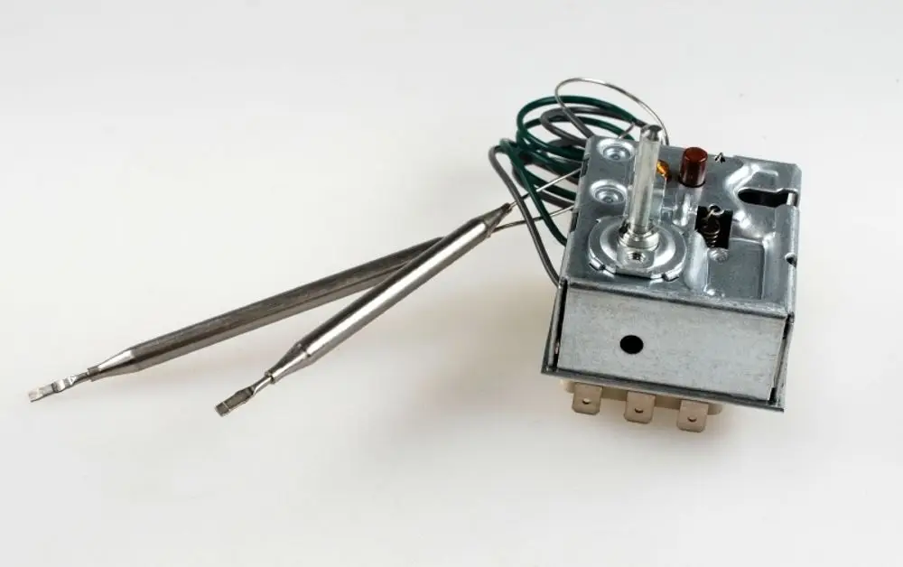 Regler von Remko mit mehreren Anschlüssen und zwei metallischen Messen. Die Bauform weist einen Drehknopf für die Temperatureinstellung auf.