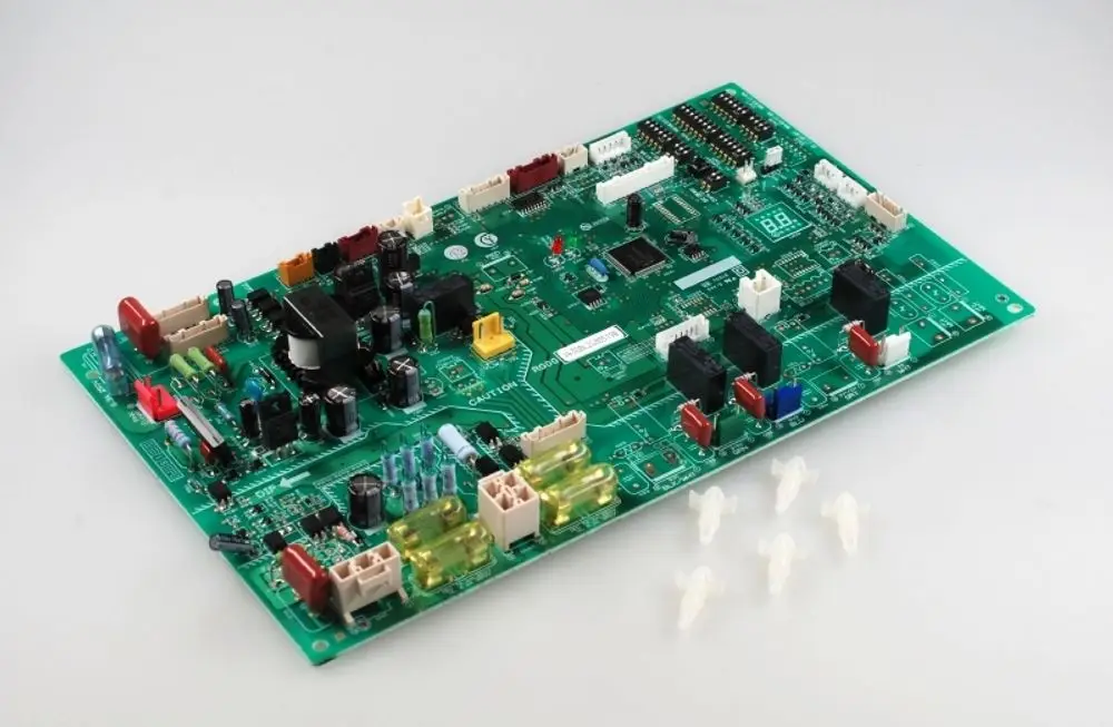 Grüne Steuerplatine mit verschiedenen elektrischen Bauteilen und Steckverbindungen, hergestellt von Remko, auf hellem Hintergrund.