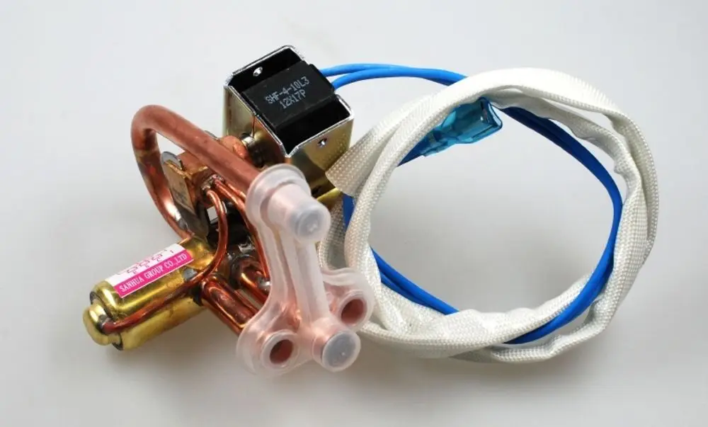 Umkehrventil mit Kupferleitungen und elektrischen Anschlüssen, hergestellt von Remko. Sichtbare Anschlusskabel sind in blau und weiß gestaltet.