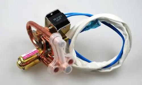 Umkehrventil mit Kupferleitungen und elektrischen Anschlüssen, hergestellt von Remko. Sichtbare Anschlusskabel sind in blau und weiß gestaltet.