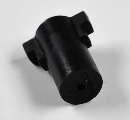 Schwarze Pumpenkupplung von Remko, zylindrische Form mit seitlichen Ausbuchtungen und einer Durchgangsbohrung an der Unterseite.