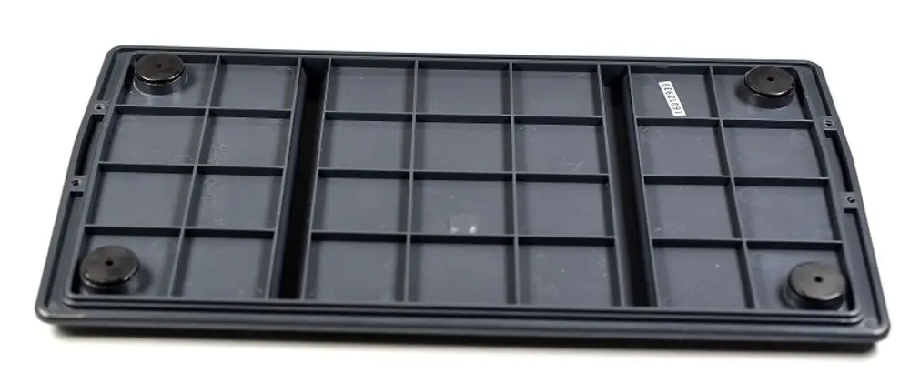 Schwarze Grundplatte mit mehreren Fächern und runden Füßen. Auf der Oberfläche befindet sich ein Aufkleber. Produkt von Remko.