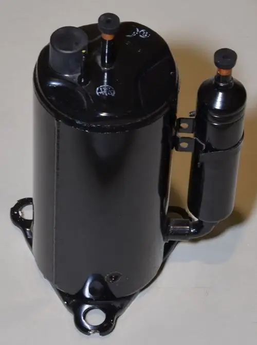 Schwarzer Kompressor von Remko mit zwei Anschlüssen und einer halbrunden Seitenkomponente. Montagebasis mit Bohrungen sichtbar.