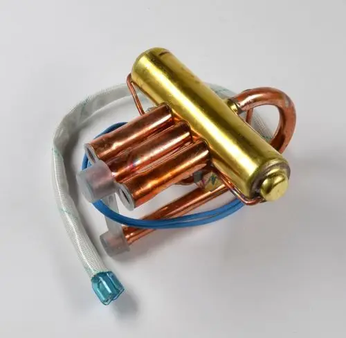 Umkehrventil in Kupfer mit einer gelben Metallkomponente, ausgestattet mit Schläuchen, für den Einsatz in Heizungs- oder Klimaanlagen der Marke Remko.