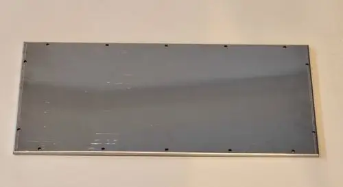 Metallplatte mit einer glatten, reflektierenden Oberfläche, umgeben von randlichen Befestigungslöchern, hergestellt von Remko.