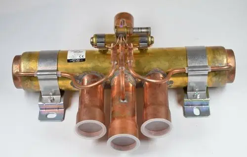 Kupferfarbenes Umkehrventil mit mehreren Anschlüssen, montiert auf einer Metallbasis. Hersteller ist Remko.
